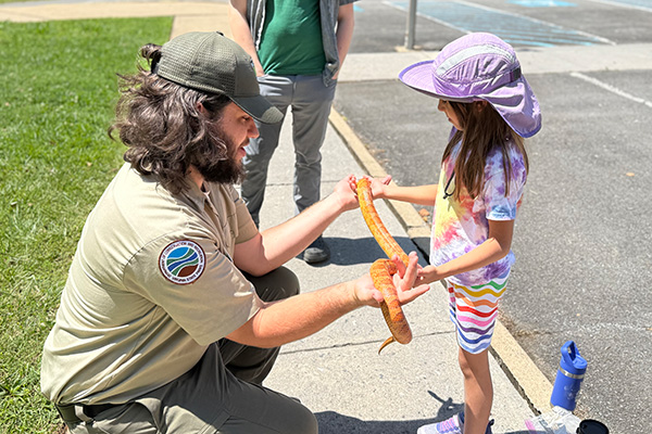 Ranger with a child holding a snake