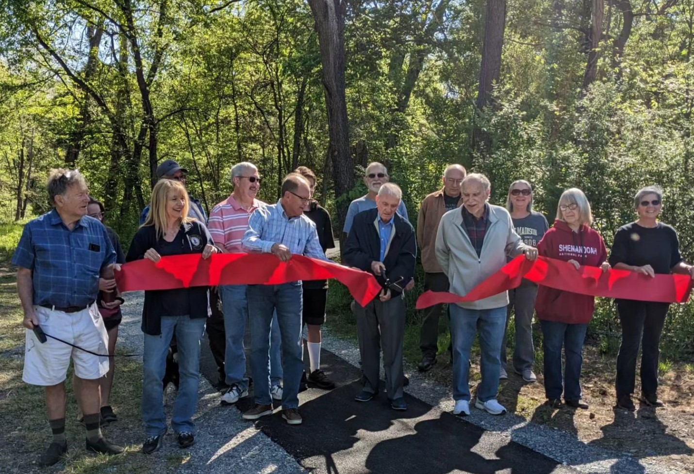 Photograph of local officials and community leaders cutting a ceremonial red ribbon.