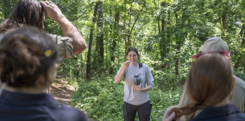 instructor showing invasive plants to group