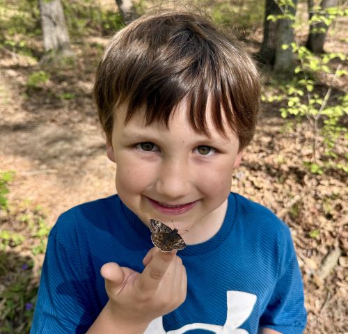 photo of child with butterfly on finger