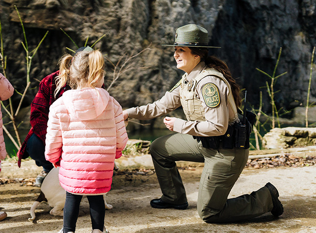 A ranger speaks with kids at the park
